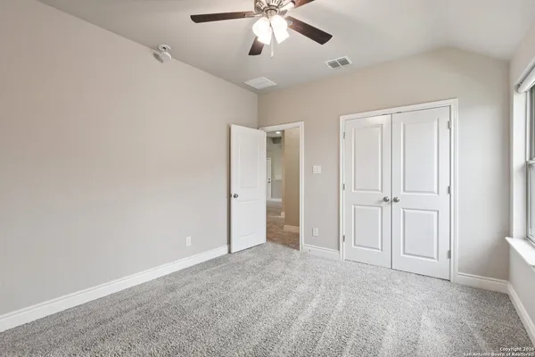 an empty room with a chandelier fan