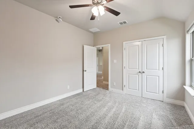 an empty room with a chandelier fan