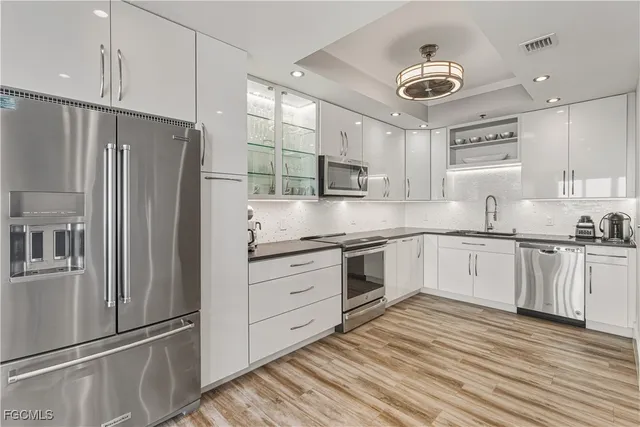 a kitchen with stainless steel appliances sink refrigerator and cabinets