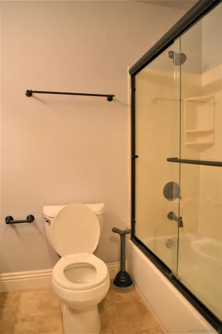 an empty room with wooden floor and a potted plant