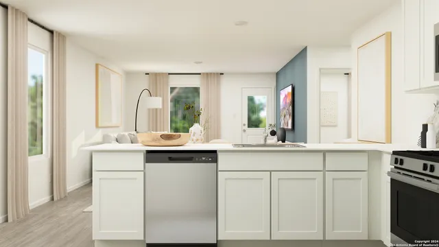 a kitchen with white cabinets and sink
