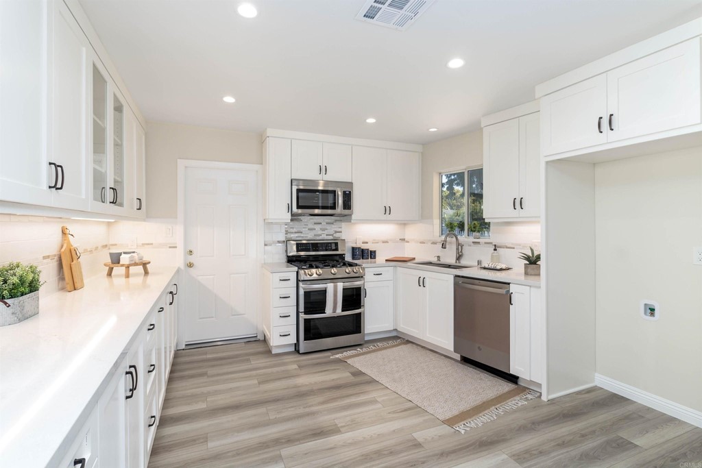 3915 Linmar Lane Carlsbad, CA 92008 - Photo 13 of 25 a kitchen with a sink white cabinets and stainless steel appliances