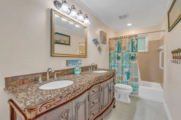 a bathroom with a granite countertop sink mirror vanity and toilet