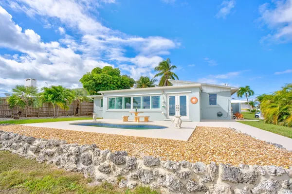 a bathroom with a granite countertop sink a toilet a mirror a vanity and shower