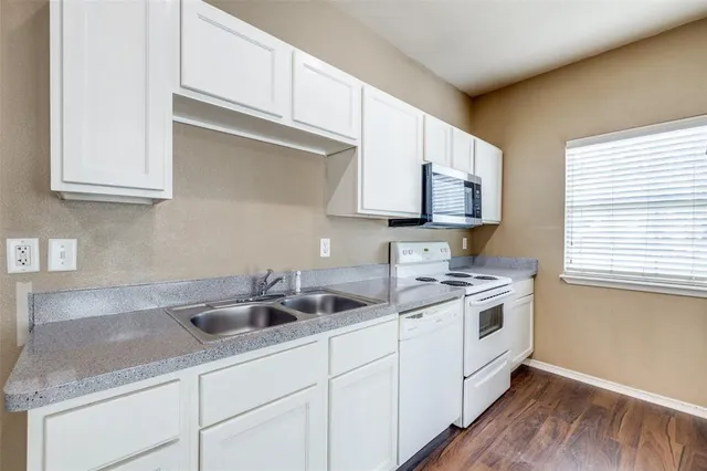 a kitchen with stainless steel appliances granite countertop a sink a stove and cabinets
