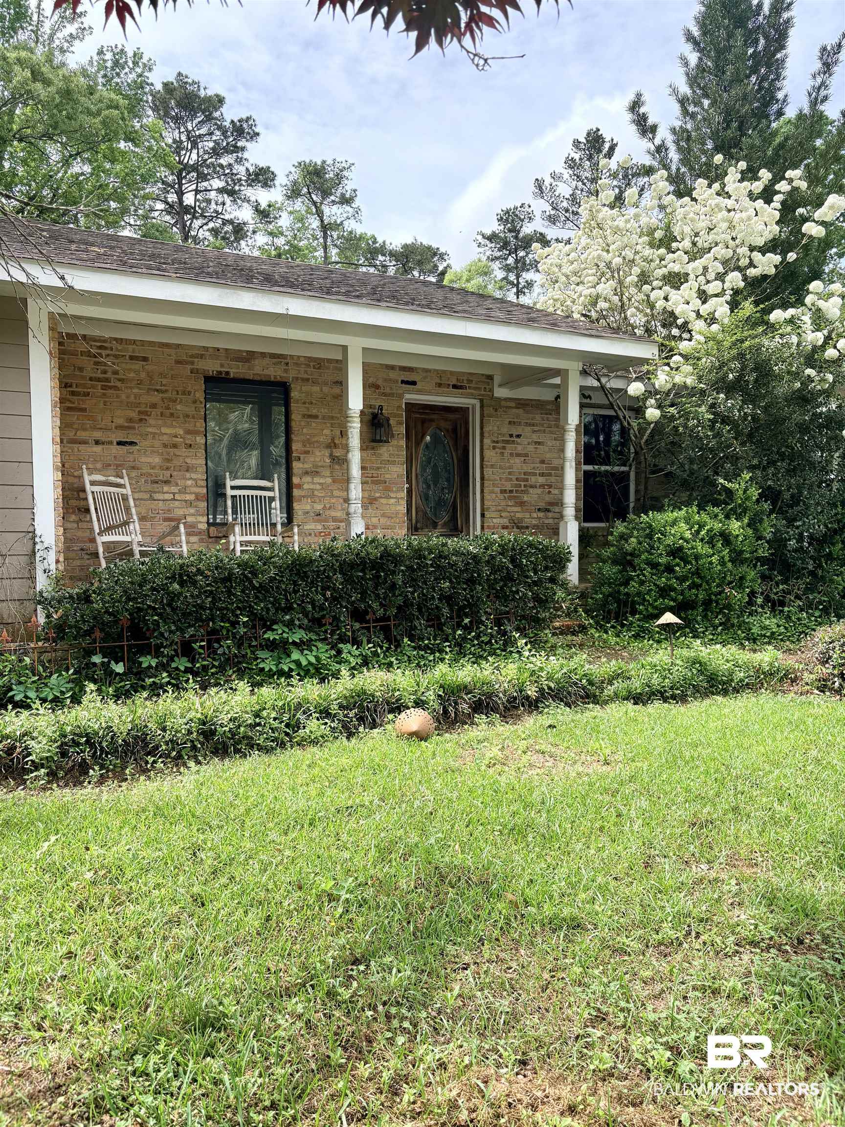 1018 Bates Road Evergreen, AL 36401 - Photo 1 of 21 Property entrance featuring a porch, brick siding, and a lawn
