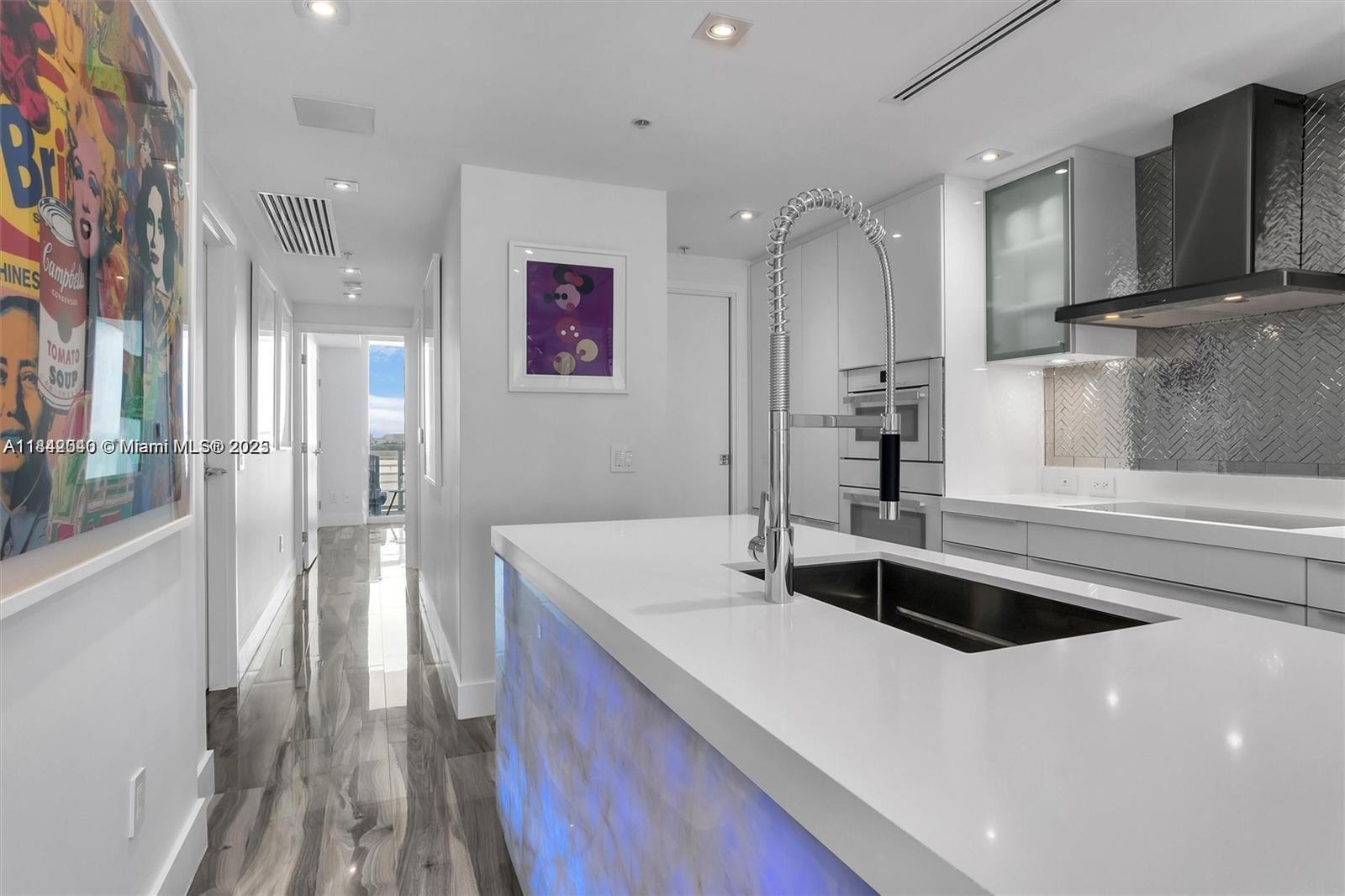 3801 Collins Avenue, Unit 1104 Miami Beach, FL 33140 - Photo 16 of 43 a kitchen with a sink and a refrigerator