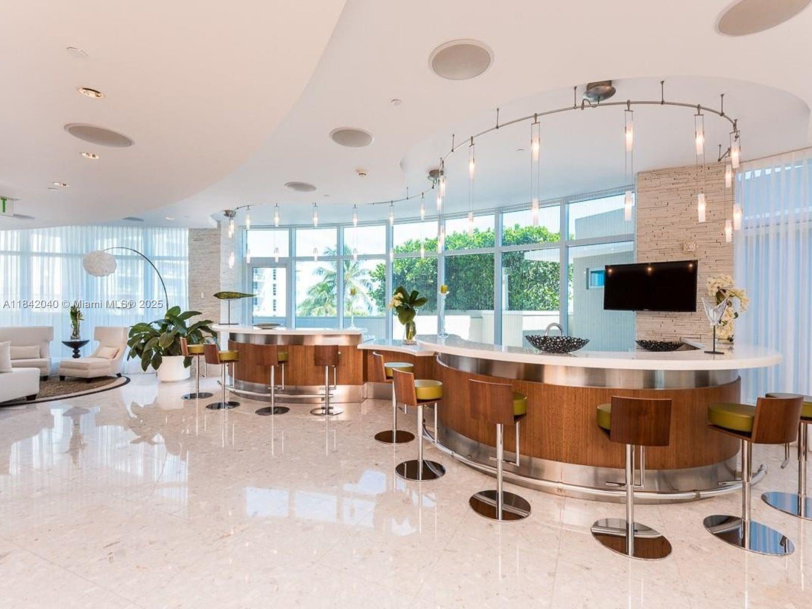 3801 Collins Avenue, Unit 1104 Miami Beach, FL 33140 - Photo 33 of 43 a kitchen with stainless steel appliances kitchen island granite countertop a sink and cabinets