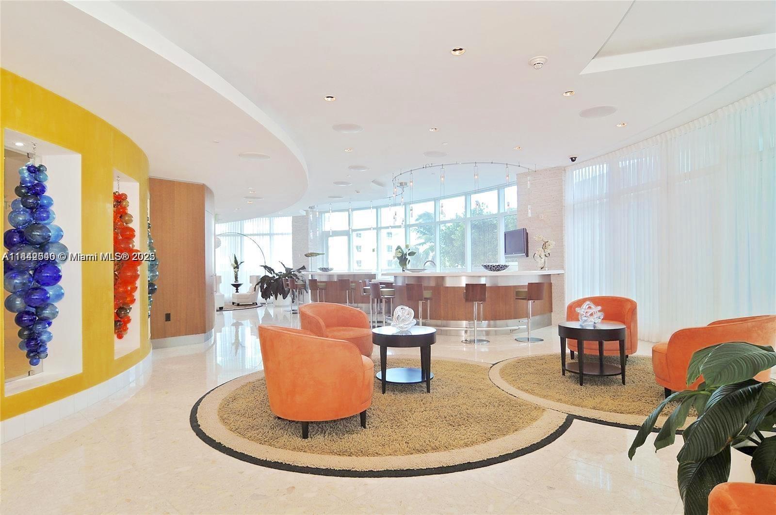 3801 Collins Avenue, Unit 1104 Miami Beach, FL 33140 - Photo 34 of 43 a dining room with large windows a glass table and chairs