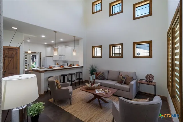 a living room with furniture kitchen view and a window