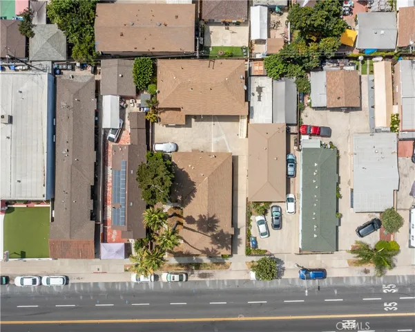 an aerial view of residential houses with outdoor space and parking