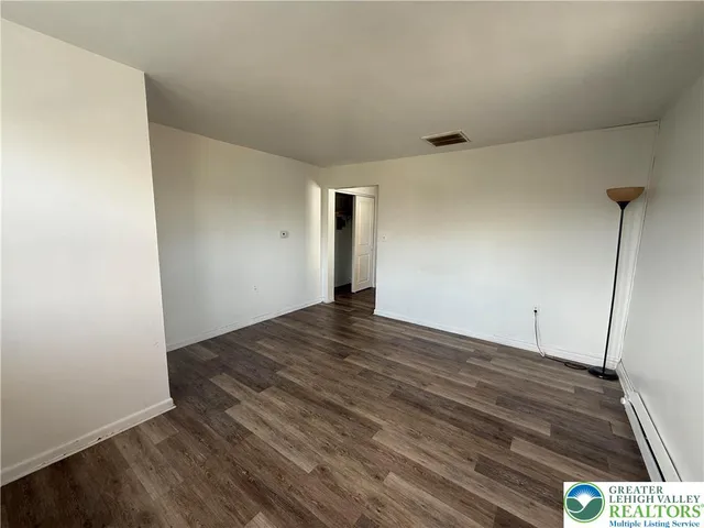 a view of empty room with wooden floor