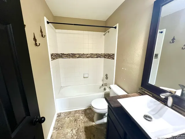 a bathroom with a sink a toilet a mirror a bathtub and shower