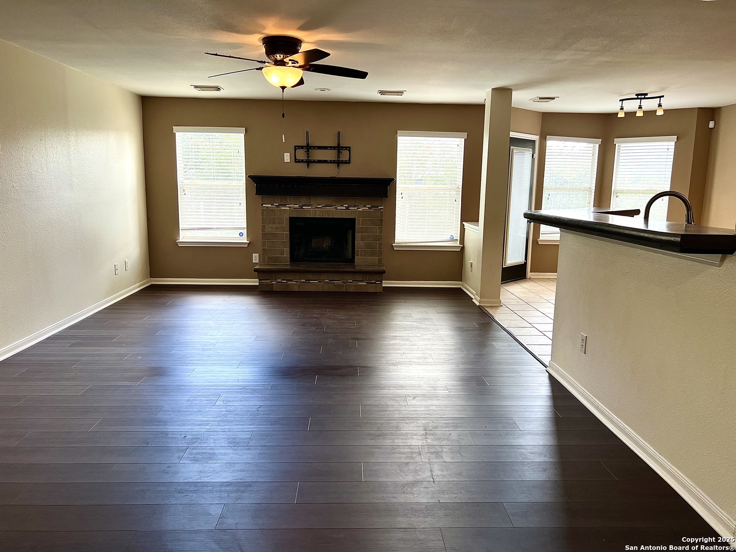 8218 Coppergate Converse, TX 78109 - Photo 3 of 15 an empty room with wooden floor a fireplace and windows