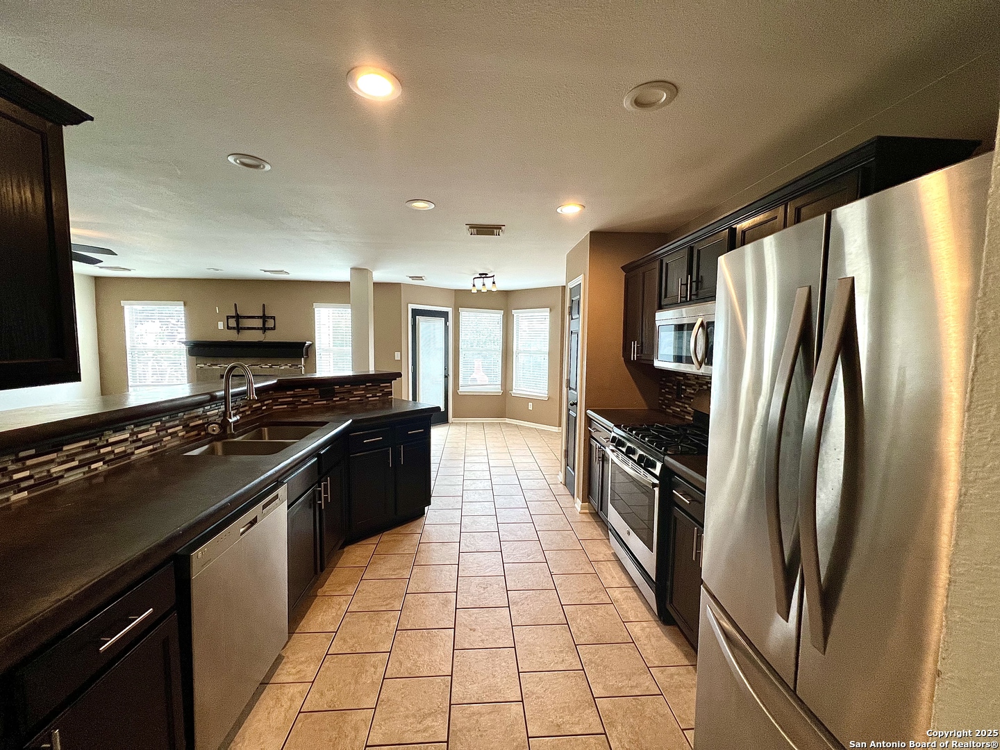 8218 Coppergate Converse, TX 78109 - Photo 5 of 15 a modern kitchen with stainless steel appliances granite countertop a stove and a refrigerator