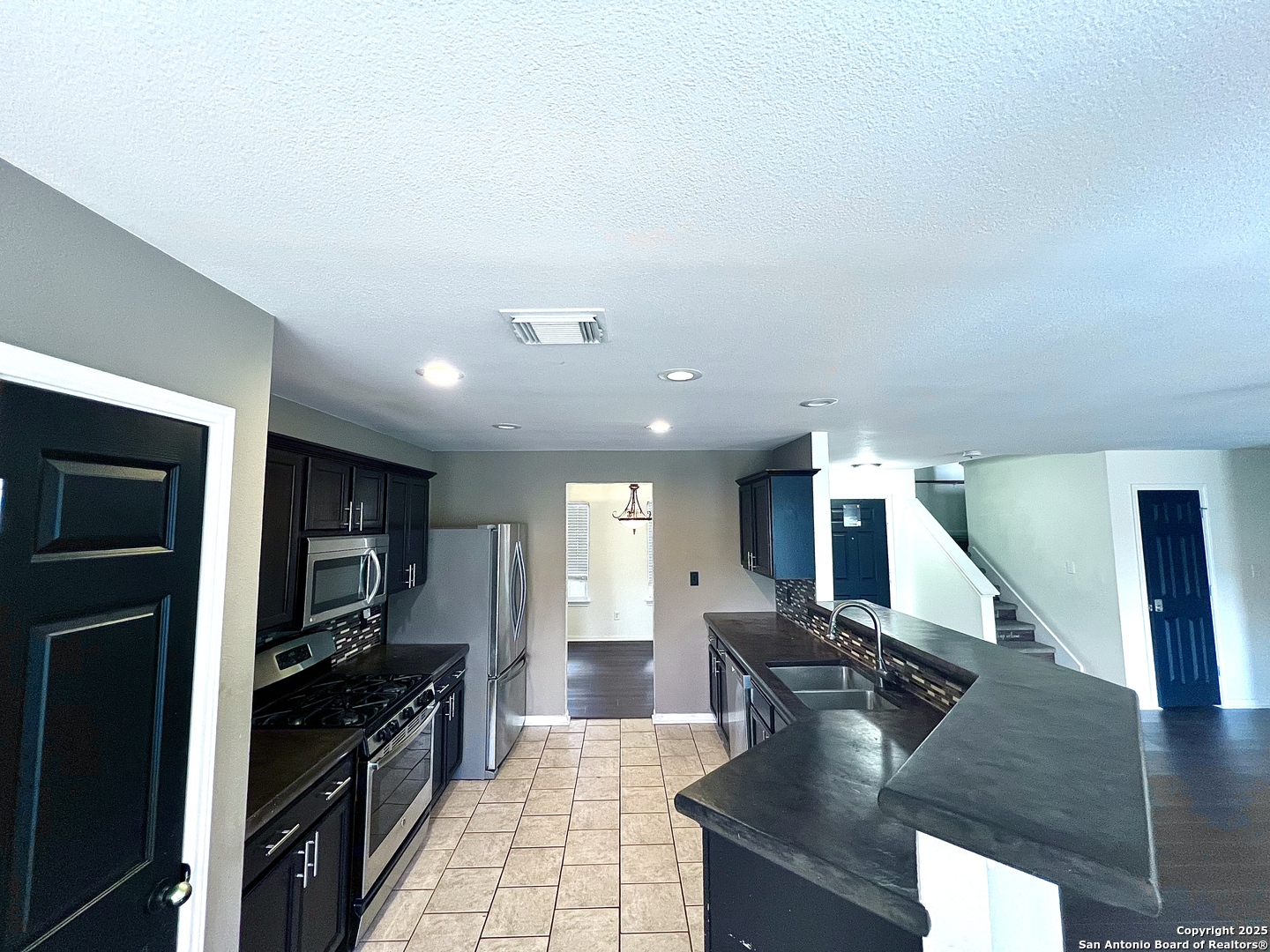 8218 Coppergate Converse, TX 78109 - Photo 6 of 15 a large kitchen with stainless steel appliances kitchen island granite countertop a large counter top cabinets and a stove