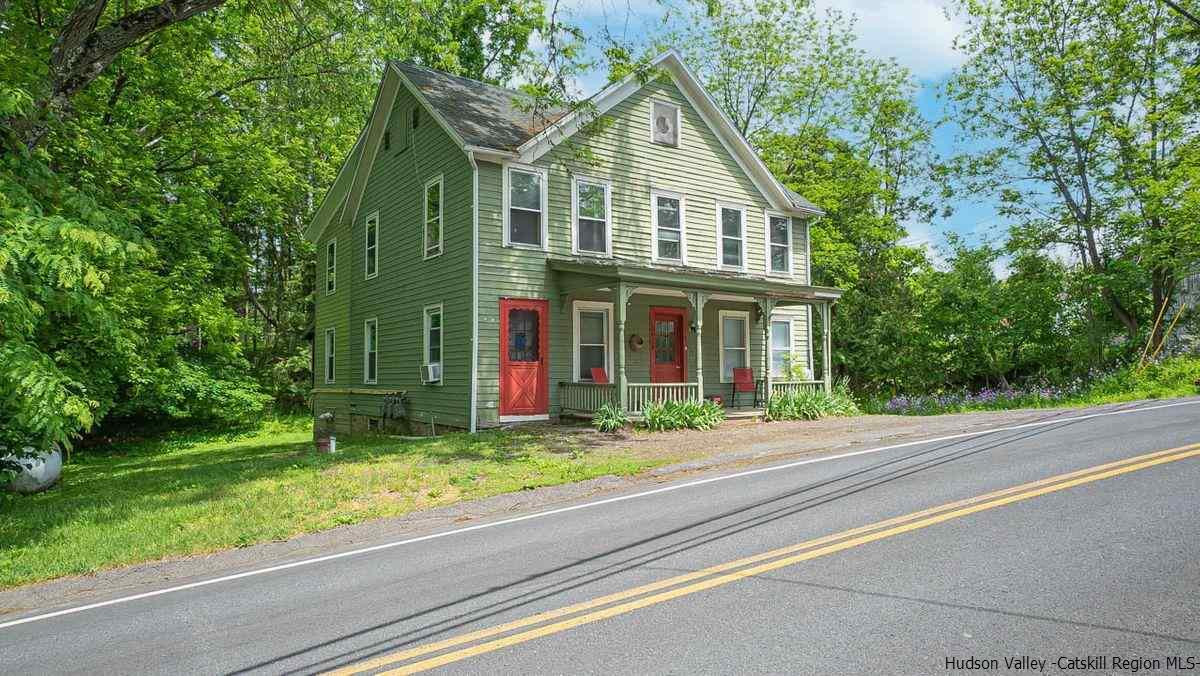 3418 Cooper Street Stone Ridge, NY 12484 - Photo 1 of 34 a front view of a house with a garden and trees