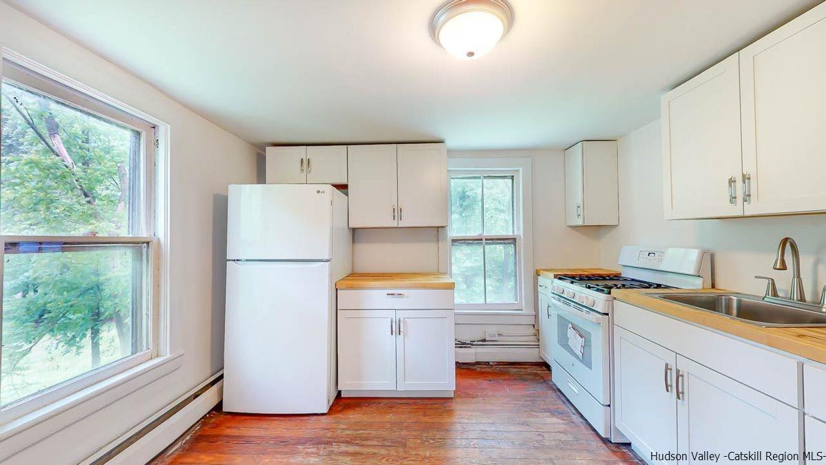 3418 Cooper Street Stone Ridge, NY 12484 - Photo 16 of 34 a kitchen with a refrigerator a stove a sink a center island and wooden floor