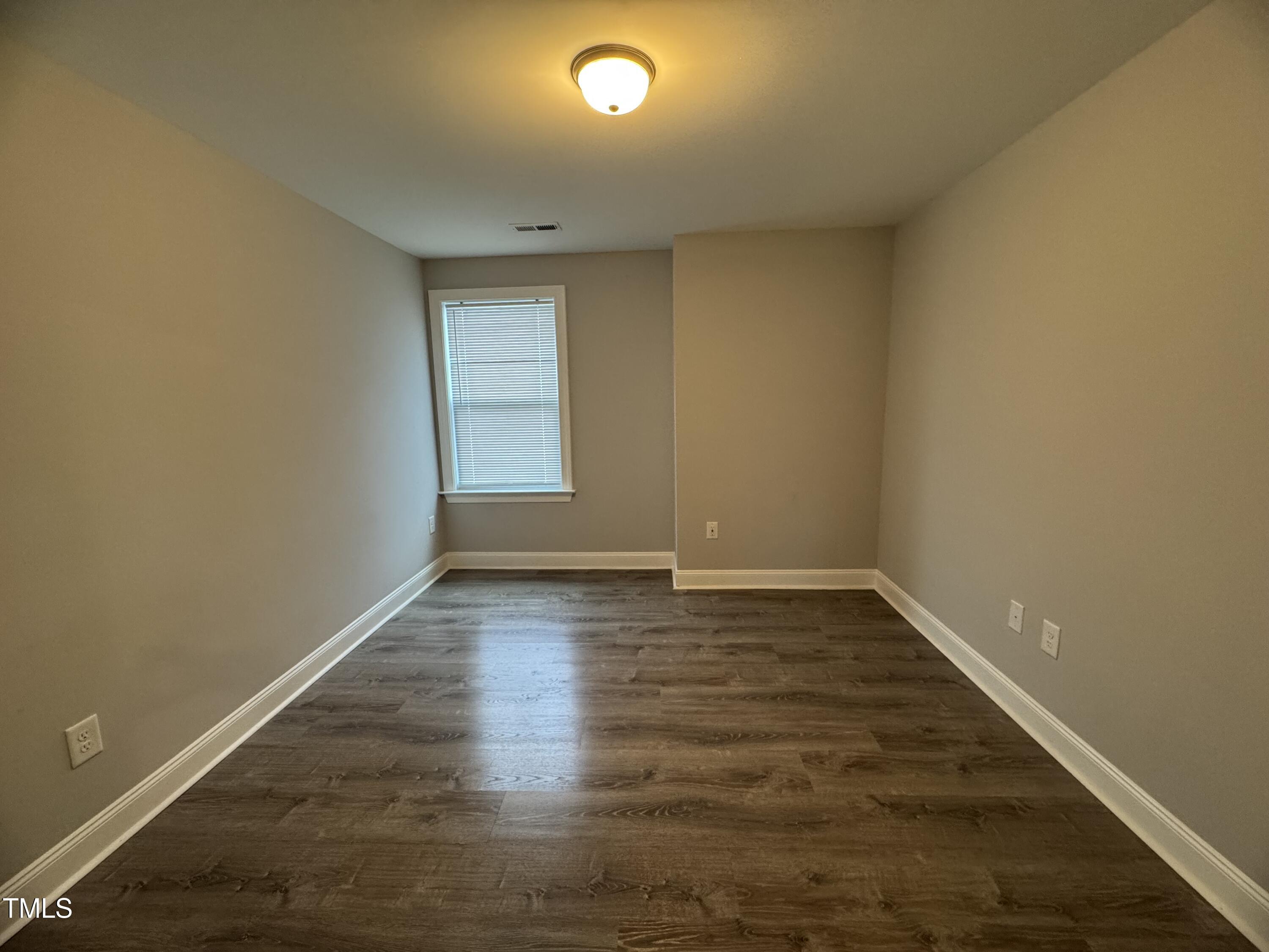 52 Shining Pearl Court Smithfield, NC 27577 - Photo 17 of 23 an empty room with wooden floor and windows