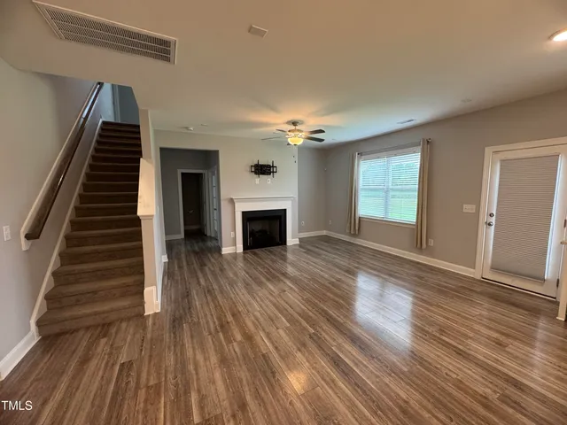 wooden floor fireplace and windows in an empty room