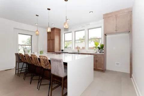 a kitchen with kitchen island granite countertop wooden cabinets and white appliances