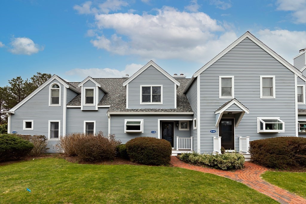 a front view of a house with a garden and plants