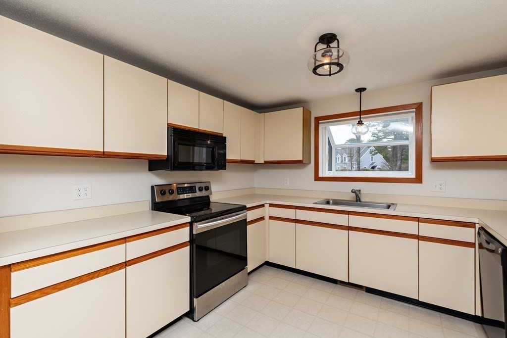 140 Shellback Way, Unit 140 Mashpee, MA 02649 - Photo 13 of 29 a kitchen with stainless steel appliances granite countertop a sink and a stove next to a window