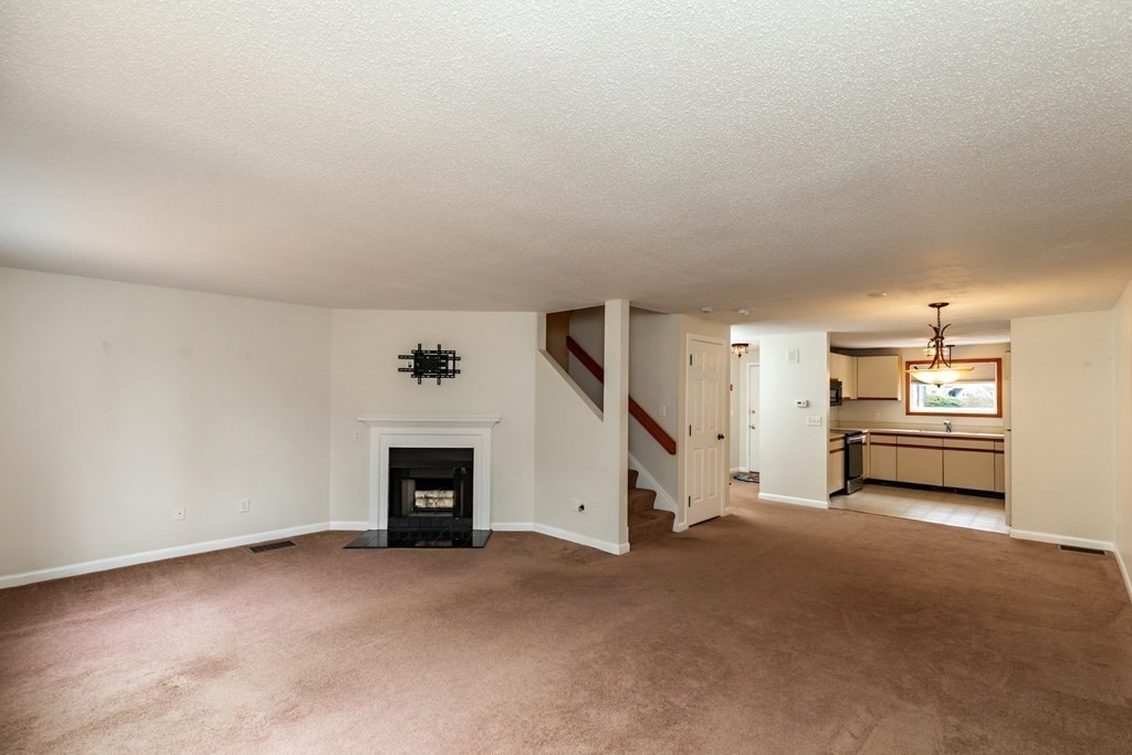 140 Shellback Way, Unit 140 Mashpee, MA 02649 - Photo 4 of 29 a view of a livingroom with an empty space and a fireplace