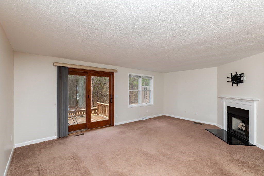 140 Shellback Way, Unit 140 Mashpee, MA 02649 - Photo 5 of 29 a view of an empty room with a fireplace and a window