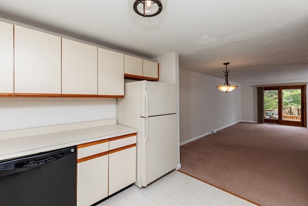 140 Shellback Way, Unit 140 Mashpee, MA 02649 - Photo 9 of 29 a kitchen with a refrigerator and cabinets
