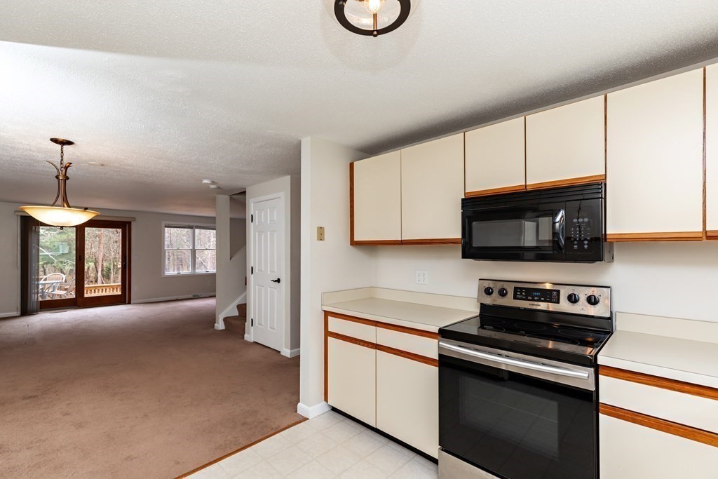 140 Shellback Way, Unit 140 Mashpee, MA 02649 - Photo 10 of 29 a kitchen with stainless steel appliances granite countertop a sink a stove and a microwave