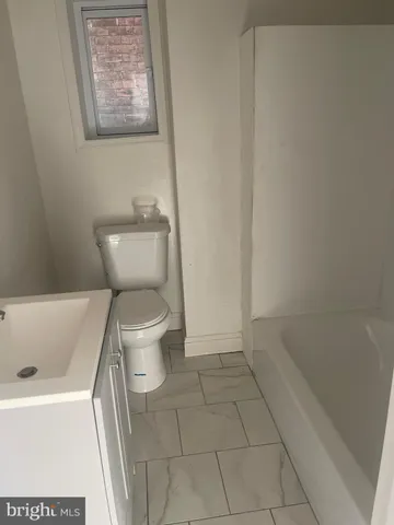 a white toilet sitting next to a bath tub