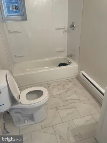 a bathroom with a toilet and a bathtub