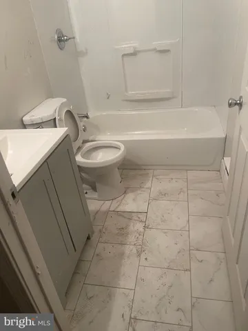 a bathroom with a granite countertop bathtub and toilet