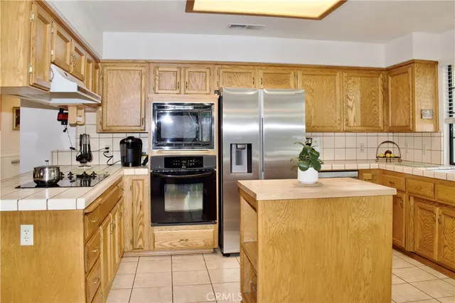 a kitchen with a sink a stove top oven and refrigerator