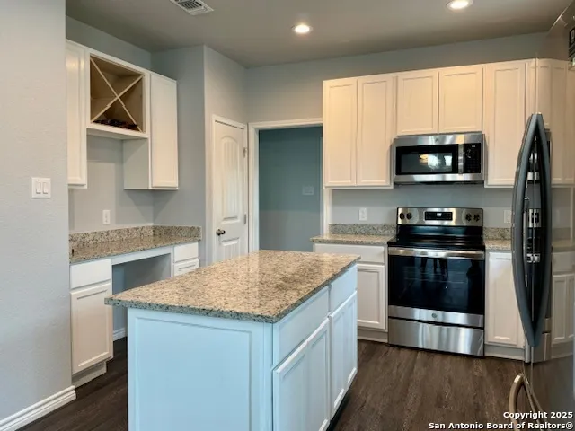a kitchen with stainless steel appliances granite countertop a stove a sink and a microwave