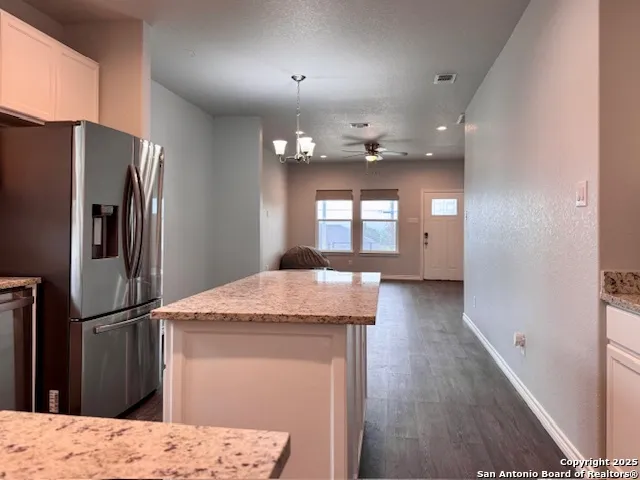 a kitchen with granite countertop a refrigerator and a sink