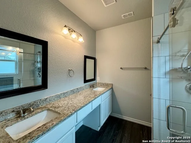 a bathroom with a granite countertop sink and a mirror