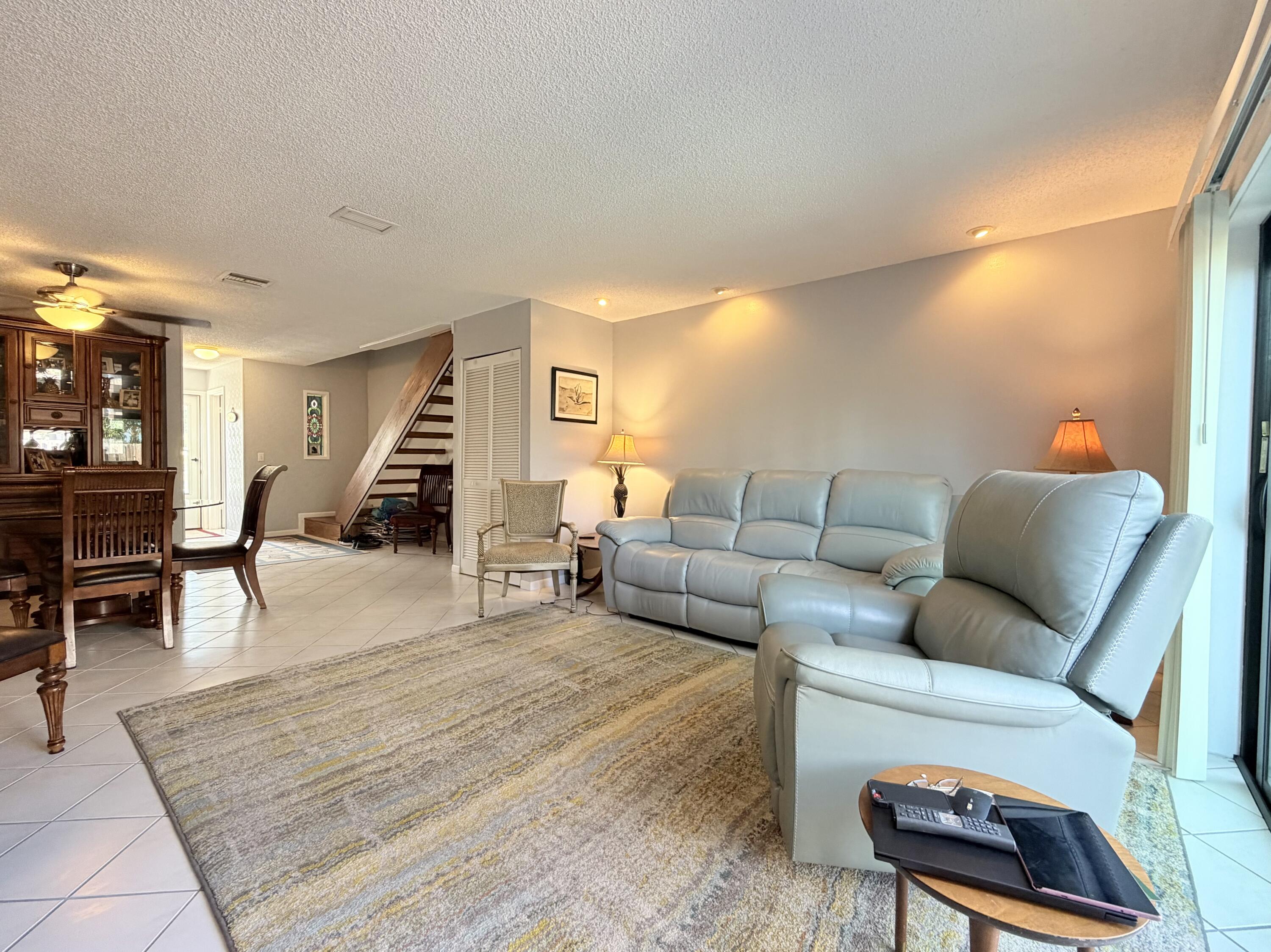 4235 North Hwy A1A, Unit 14 Hutchinson Island, FL 34949 - Photo 15 of 36 a living room with furniture and a dining table with wooden floor