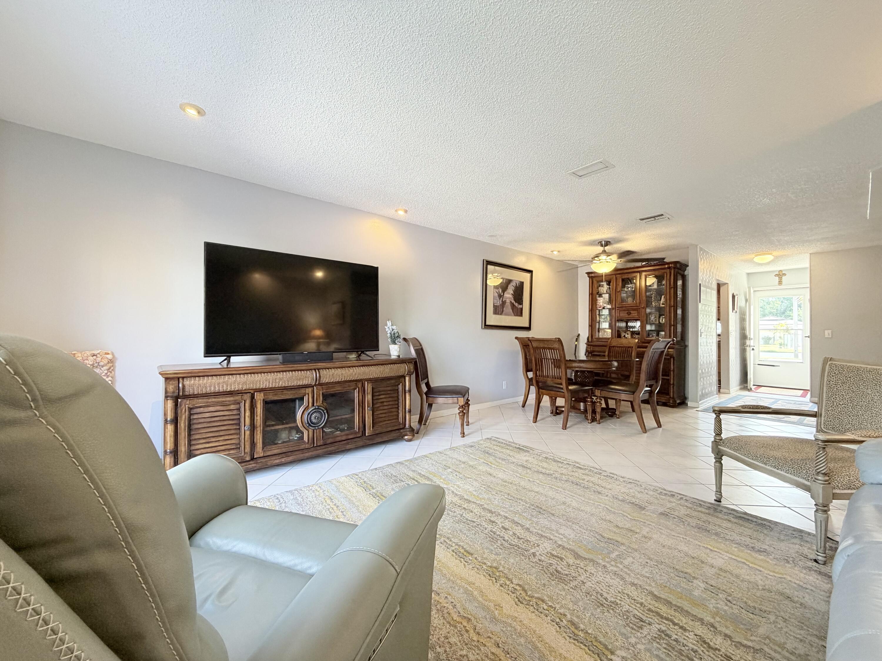 4235 North Hwy A1A, Unit 14 Hutchinson Island, FL 34949 - Photo 16 of 36 a living room with furniture and a flat screen tv