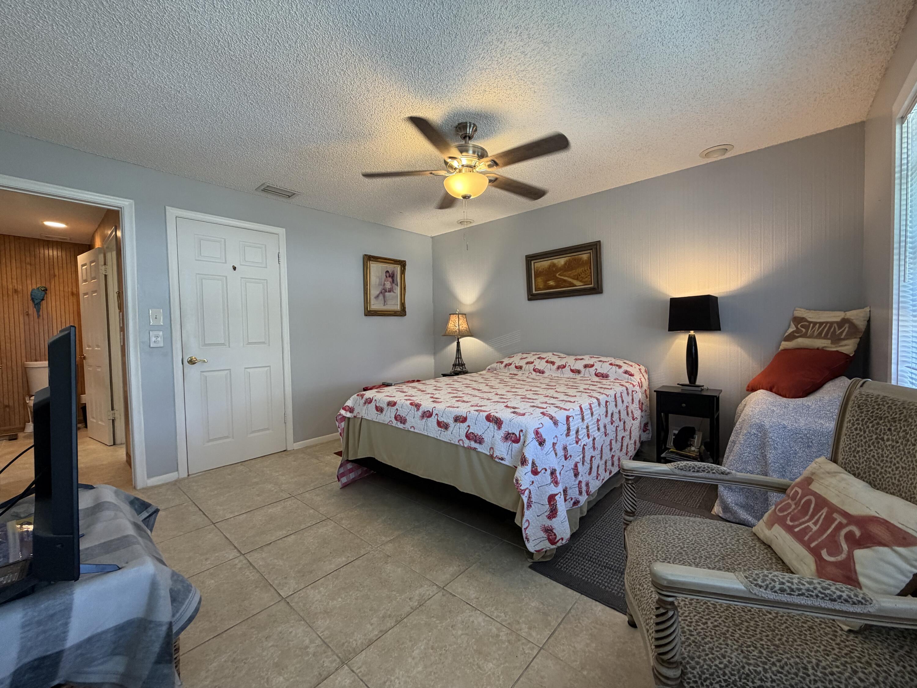 4235 North Hwy A1A, Unit 14 Hutchinson Island, FL 34949 - Photo 24 of 36 a bedroom with a bed and a chandelier
