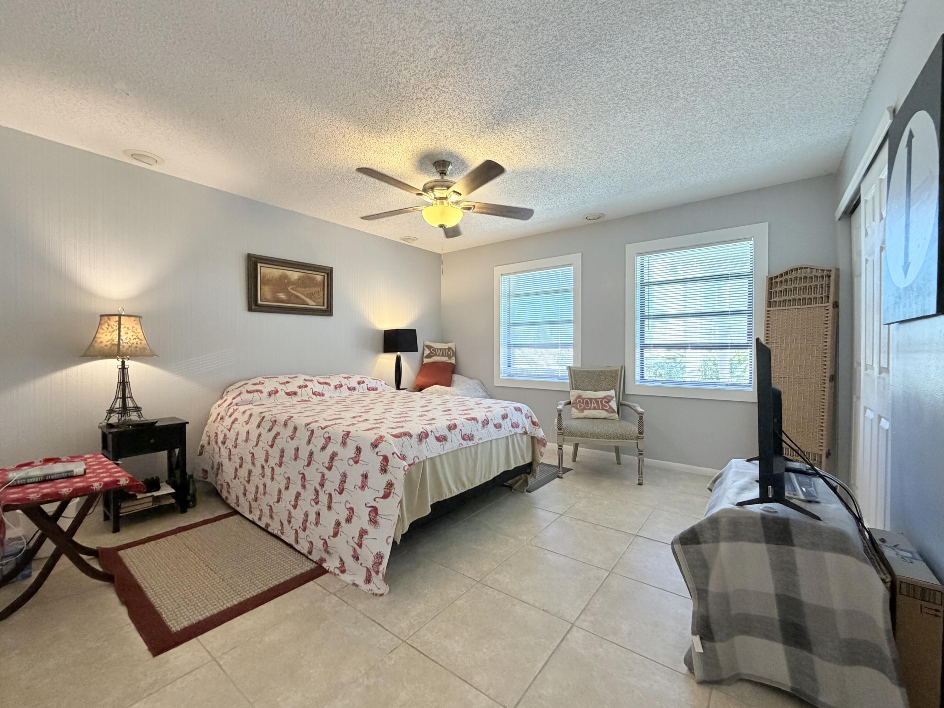 4235 North Hwy A1A, Unit 14 Hutchinson Island, FL 34949 - Photo 25 of 36 a bedroom with a bed and a chandelier