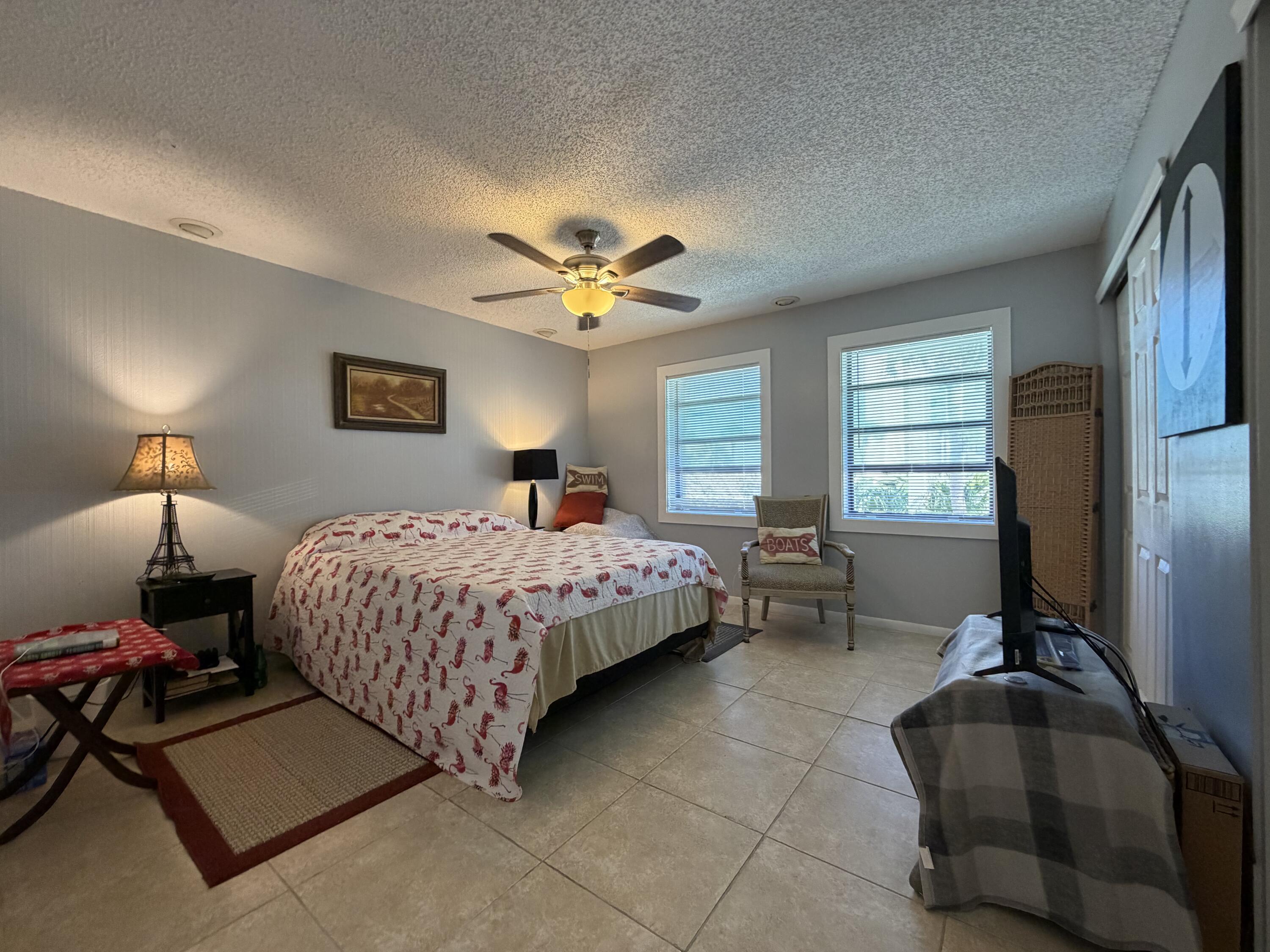 4235 North Hwy A1A, Unit 14 Hutchinson Island, FL 34949 - Photo 26 of 36 a bedroom with a bed and a chandelier