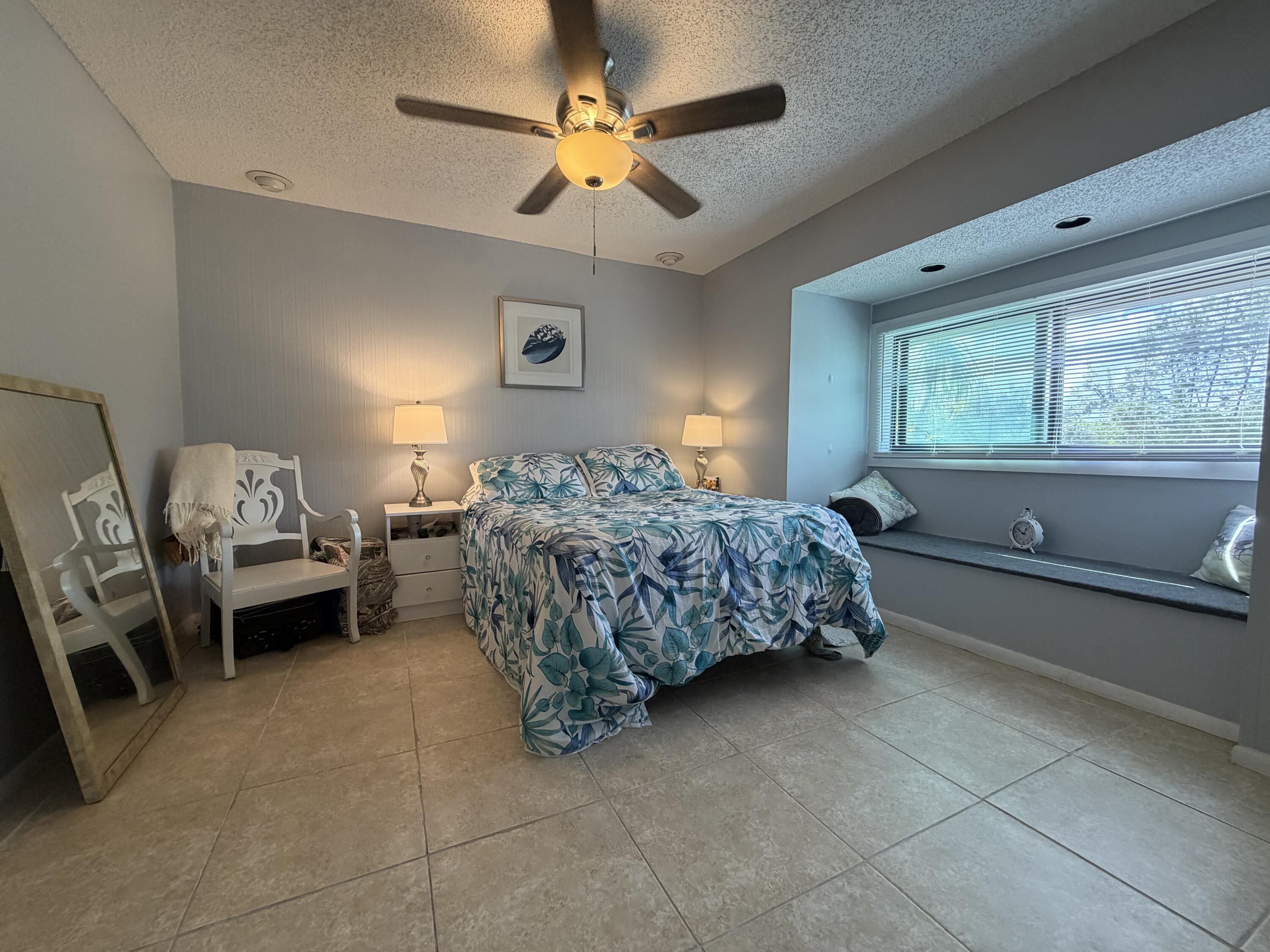 4235 North Hwy A1A, Unit 14 Hutchinson Island, FL 34949 - Photo 28 of 36 a bedroom with a bed and a chandelier
