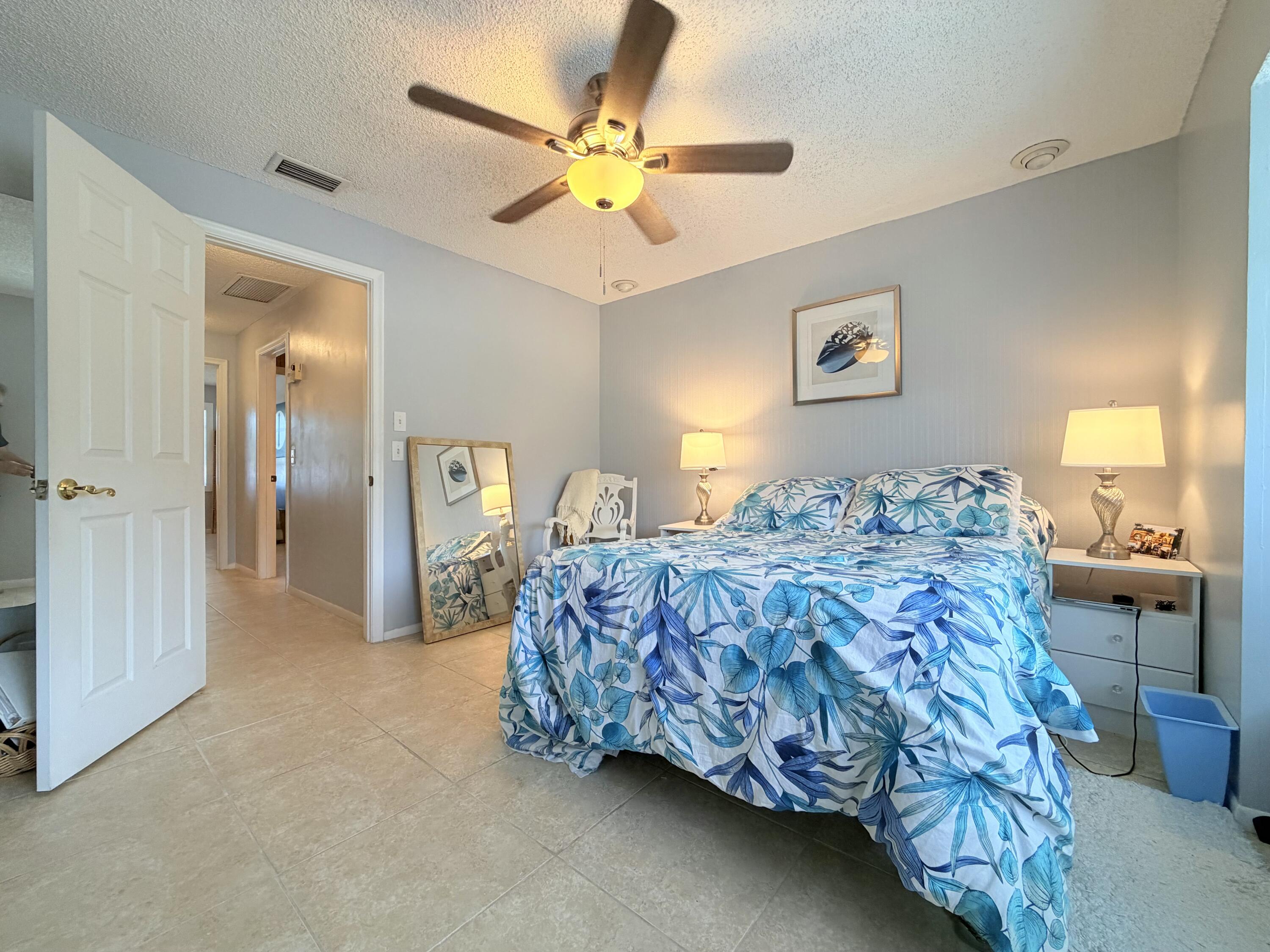 4235 North Hwy A1A, Unit 14 Hutchinson Island, FL 34949 - Photo 29 of 36 a bedroom with a bed and a chandelier
