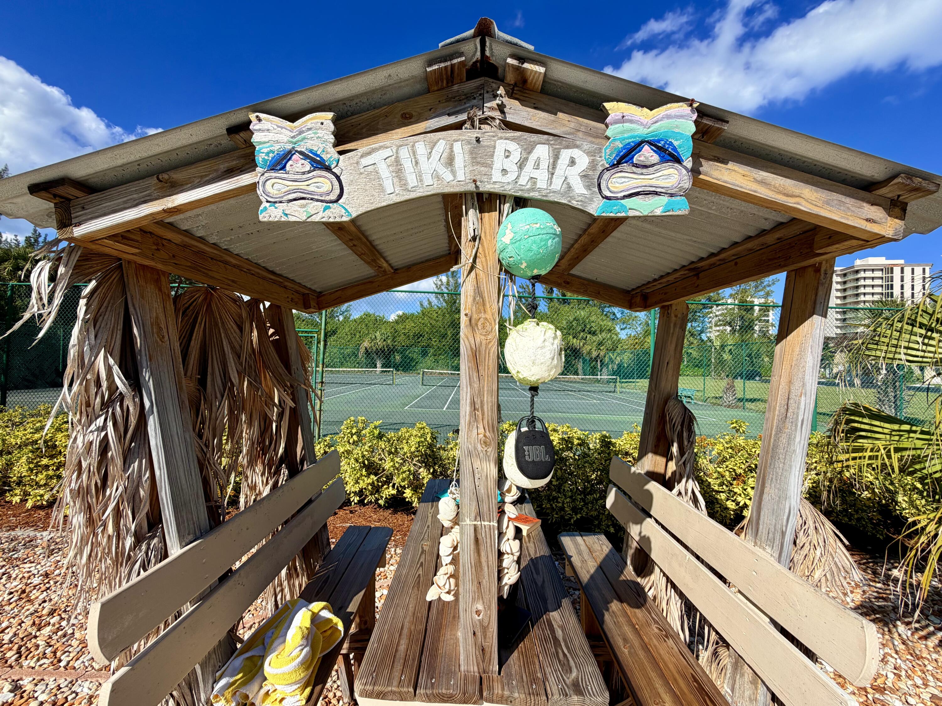 4235 North Hwy A1A, Unit 14 Hutchinson Island, FL 34949 - Photo 31 of 36 a view of a patio with table and chairs potted plants with wooden floor