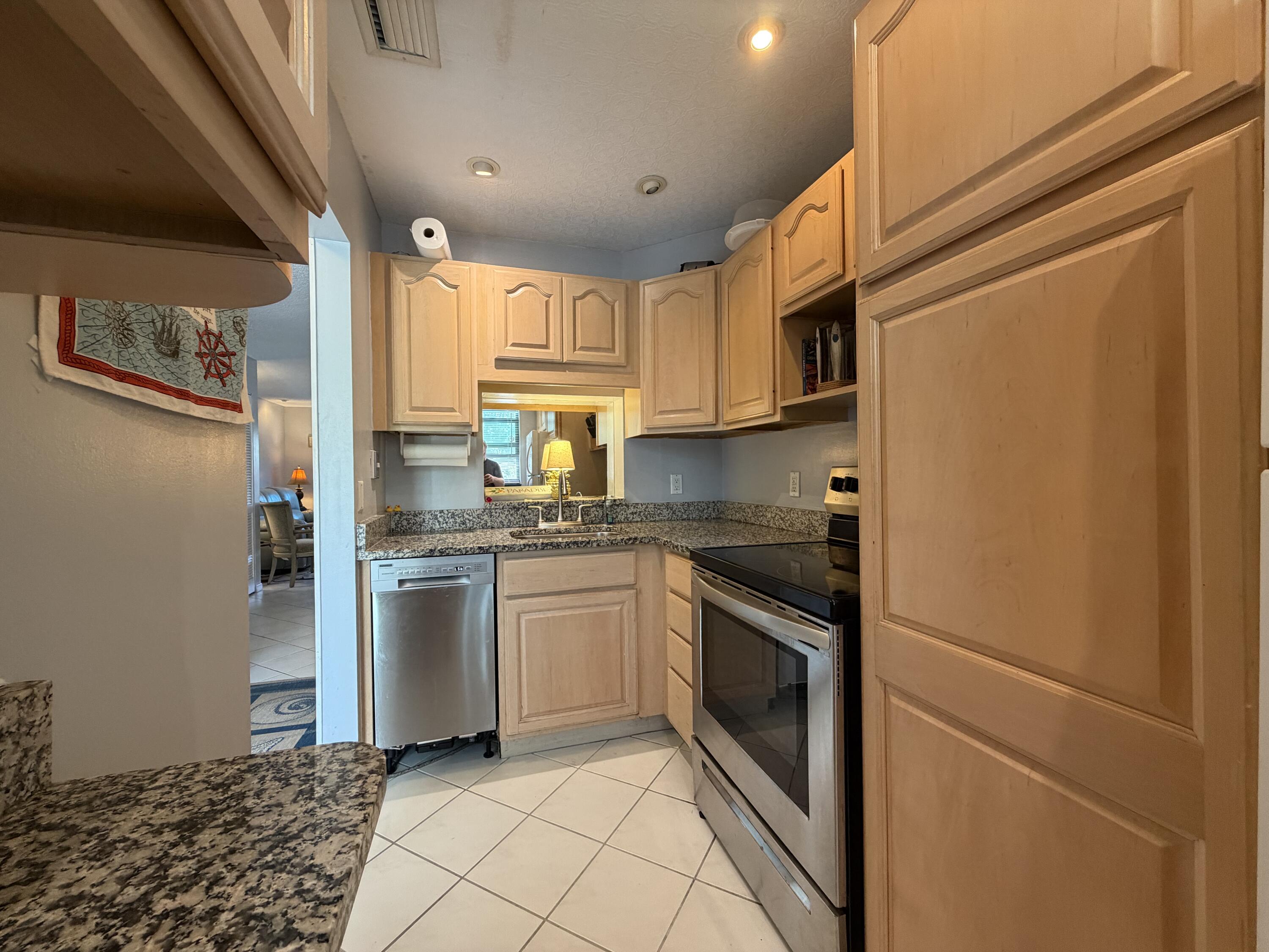 4235 North Hwy A1A, Unit 14 Hutchinson Island, FL 34949 - Photo 7 of 36 a kitchen with stainless steel appliances granite countertop a refrigerator sink and stove