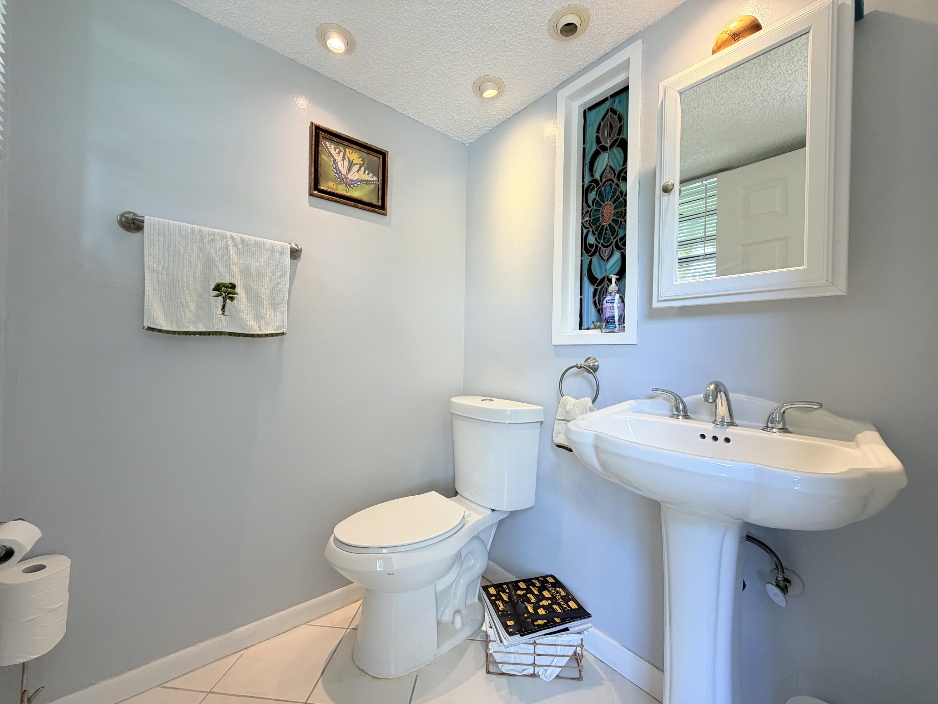 4235 North Hwy A1A, Unit 14 Hutchinson Island, FL 34949 - Photo 10 of 36 a bathroom with a sink toilet and mirror