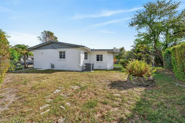 a backyard of a house with plants and tree