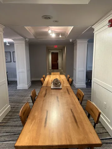 a room with wooden floor pool table and windows